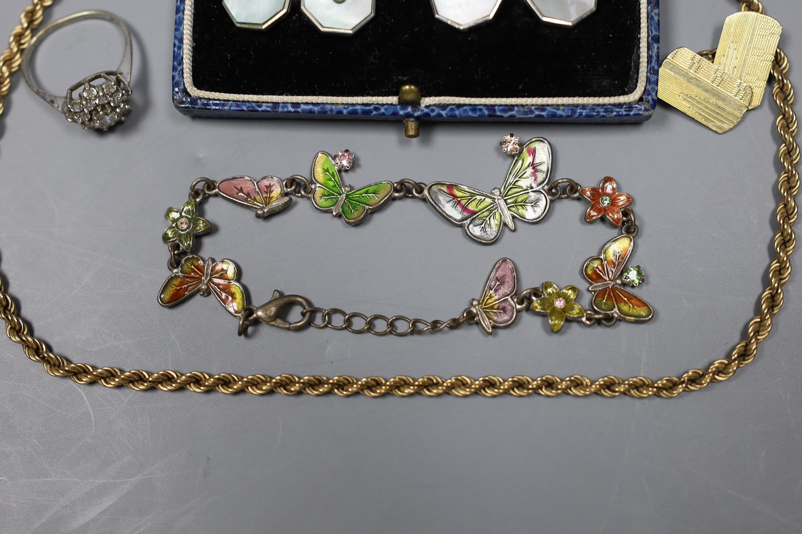 A modern 9ct gold rope twist chain, 5.2 grams, a white metal and enamel butterfly link bracelet, a pair of mother of pearl and base metal cufflinks in box, a gold plated cufflink and a silver dress ring.